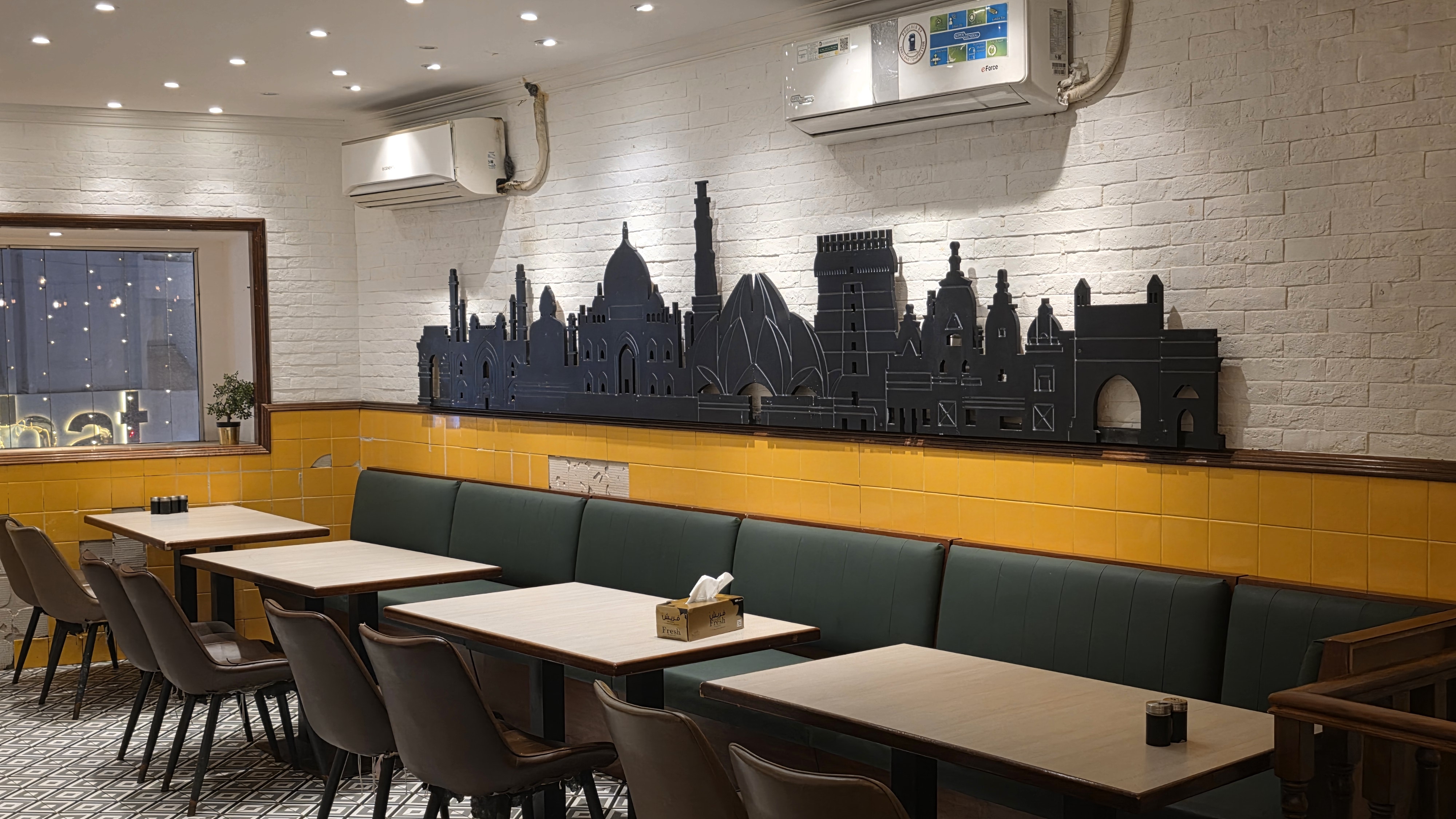 Mini Punjab dining room with the India skyline wall and green banquettes